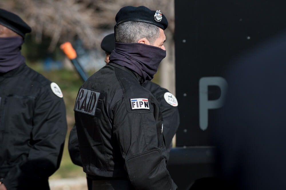 Membre du RAID en uniforme noir avec les inscriptions 'RAID' et 'FIPN'.