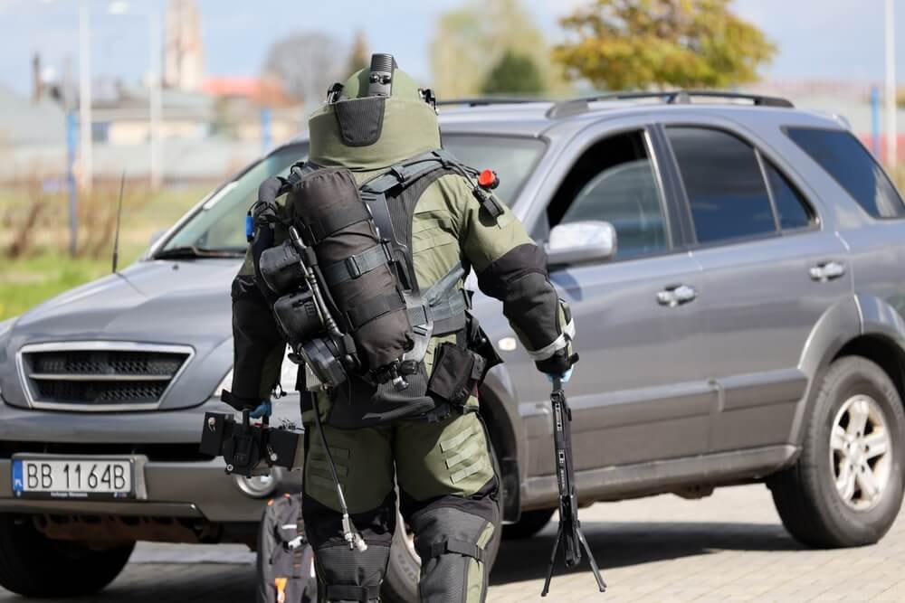 Policier démineur s'approchant d'un véhicule.
