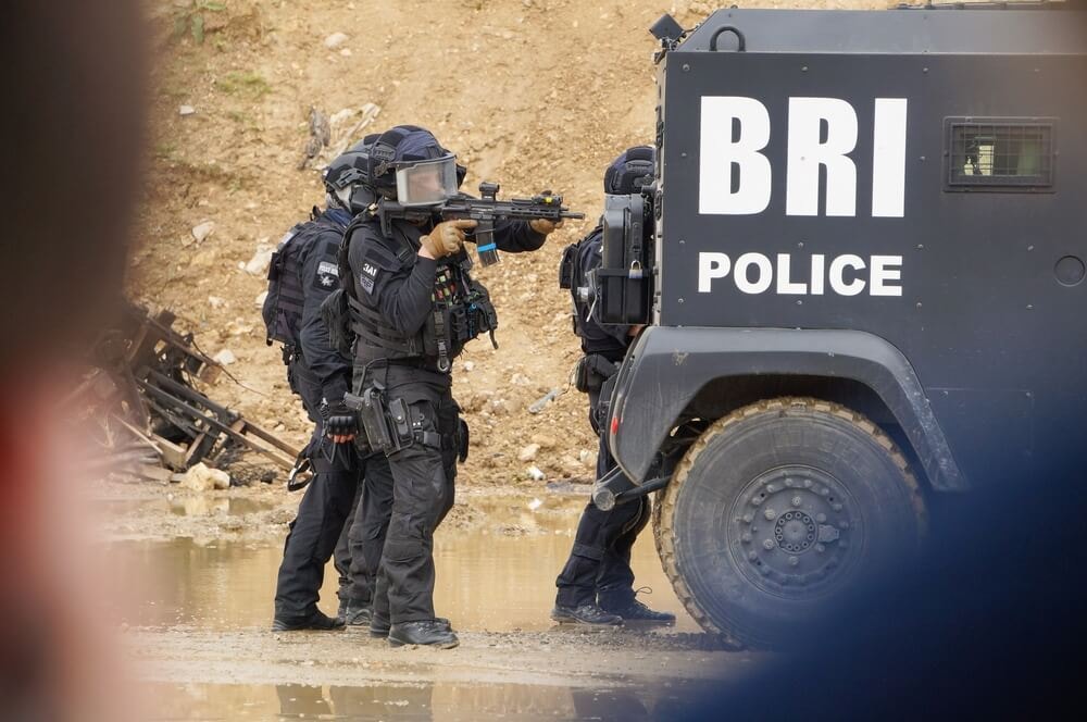 Membres de la BRI en action près de leur véhicule.