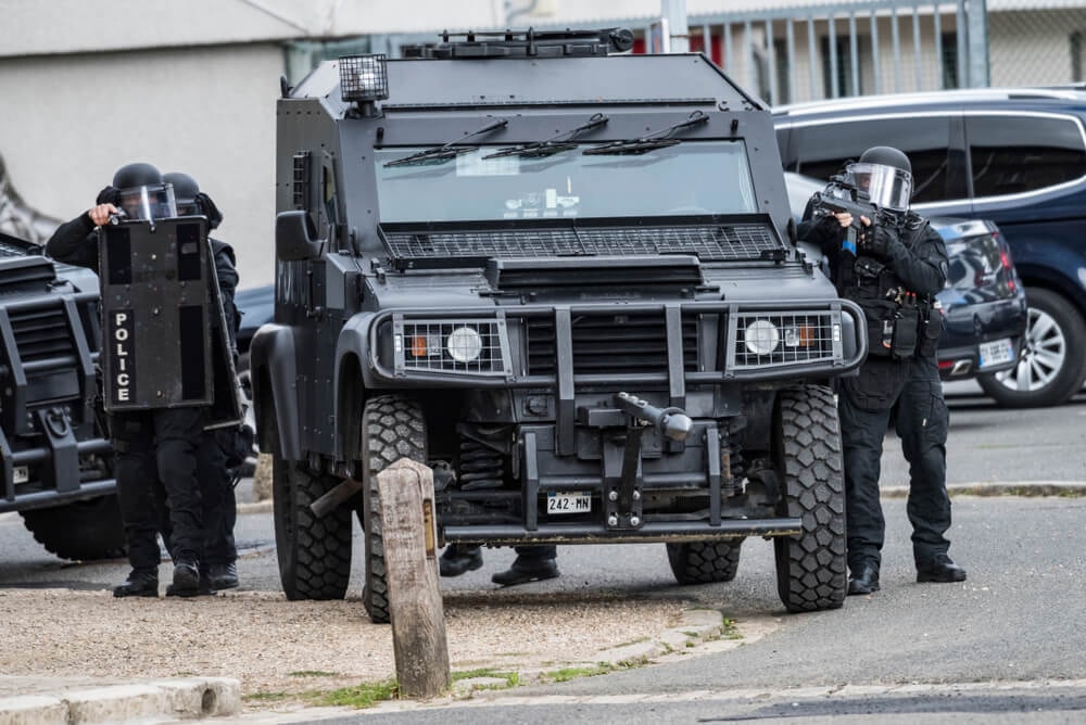 Véhicule blindé du RAID et policiers équipés.
