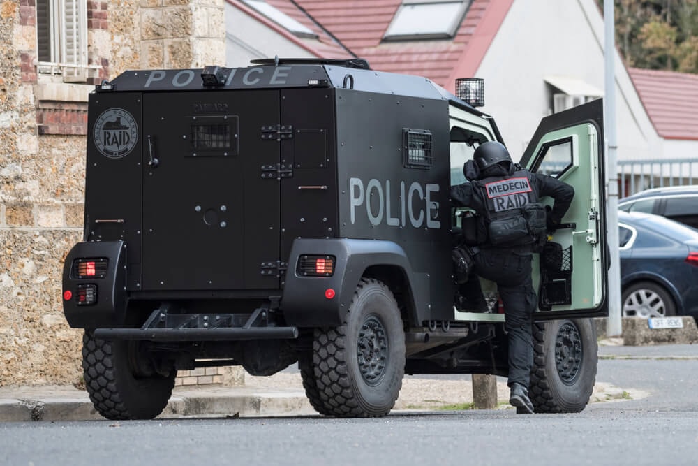 Véhicule blindé du RAID et un membre de l'unité 'Médecin RAID'.