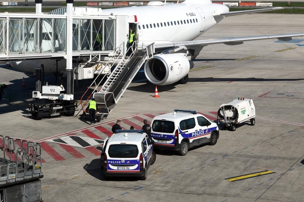 Véhicules de la Police aux Frontières près d'un avion.
