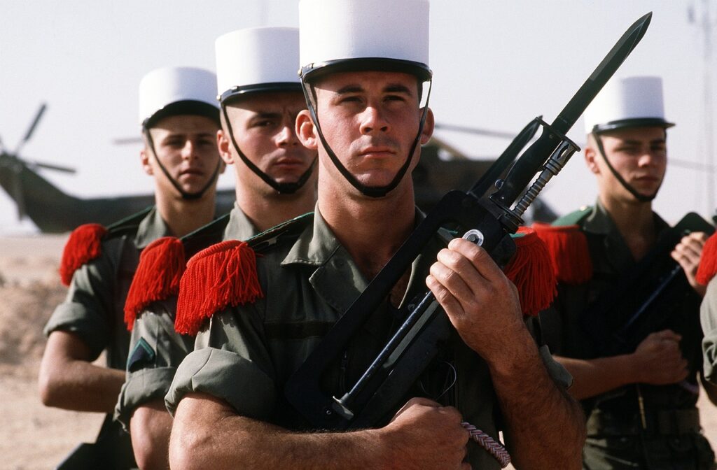 Un groupe de soldats de la Légion Étrangère en uniforme avec képis blancs et épaulettes rouges