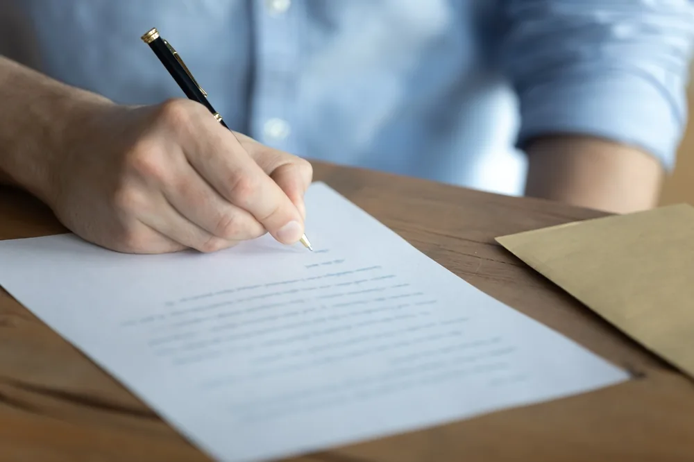 Bureau avec lettre de motivation imprimée, stylo et dossier de candidature pour l'Armée de Terre.