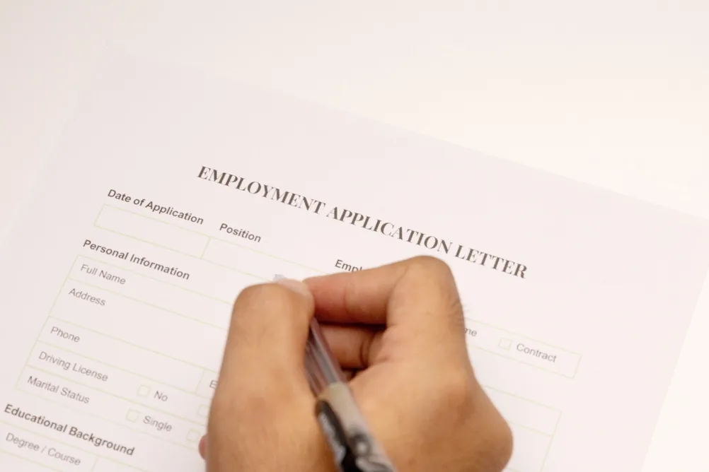 Bureau avec papier blanc, stylo et documents officiels pour une candidature militaire.