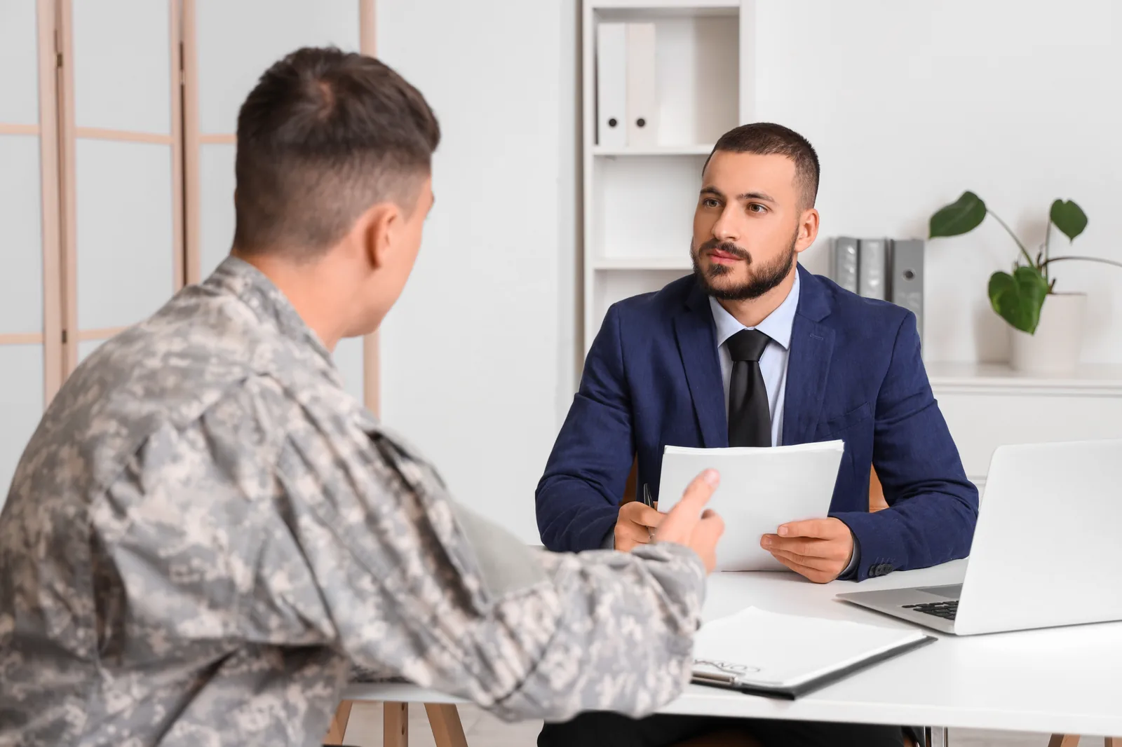 Officier militaire conduisant un entretien individuel de recrutement avec un candidat en uniforme.