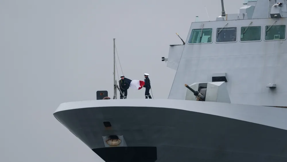 Marins en formation sur le pont d'un navire militaire en mer.
