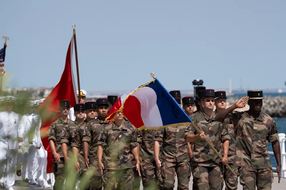 Soldat de l'Armée de Terre en tenue de combat, lettre de motivation posée sur un bureau.