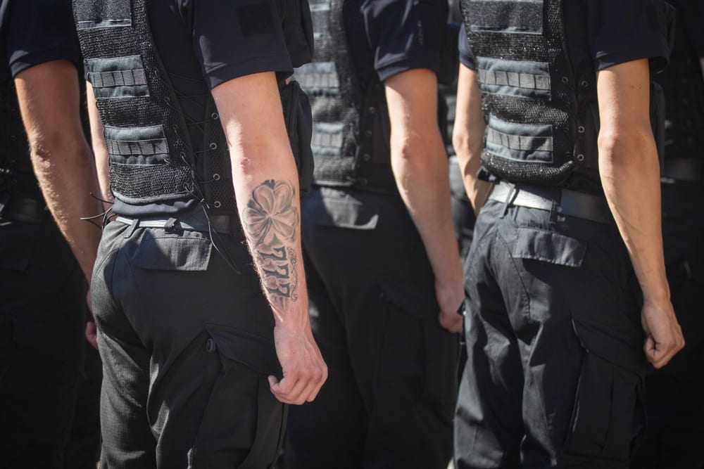 Bras tatoué recouvert par une manche d'uniforme de policier