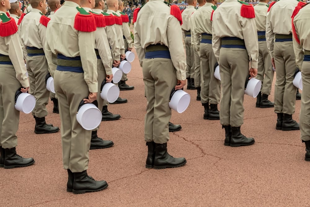 Légionnaires en uniforme de parade tenant leur képi blanc à la main, symbole emblématique de la Légion étrangère.