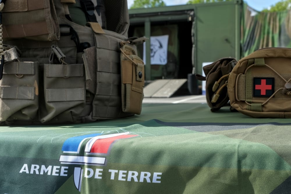 Gilet tactique et kit médical de l'armée de Terre sur un support logoté, illustrant la force opérationnelle terrestre.