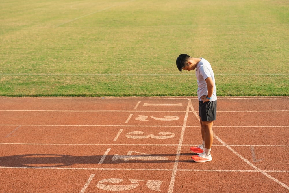 Candidat en tenue de sport sur une piste d'athlétisme lors d'un test d'aptitude physique militaire.
