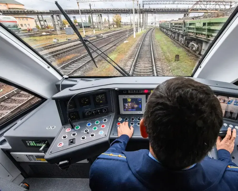 Conducteur de train aux commandes, vue de la cabine sur la voie