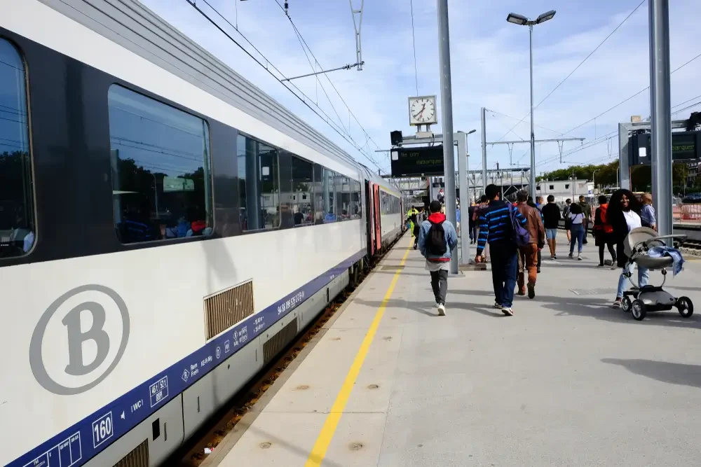 Rame SNCB à quai au moment du départ, voyageurs et agent en gilet sur le quai