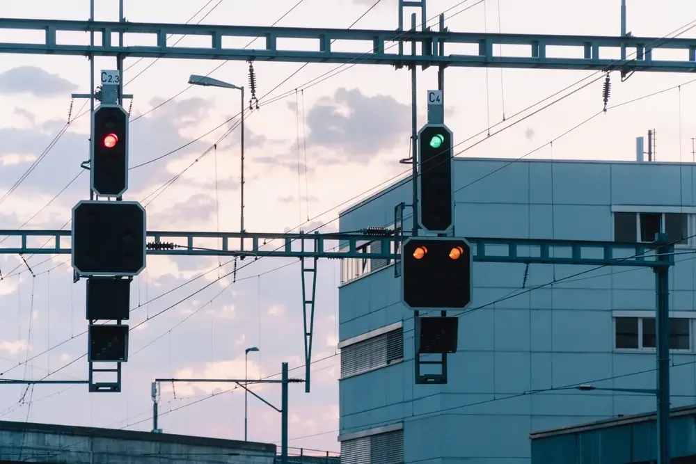 Signaux ferroviaires au-dessus des voies, présentant le rouge, le vert et deux feux jaunes