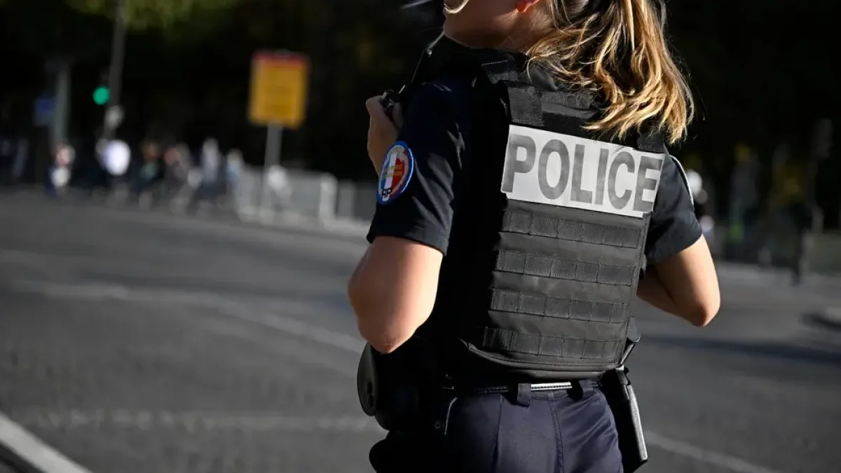 Policière de la Police nationale française de dos en uniforme et gilet tactique avec écusson Académie de Police