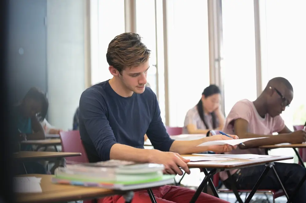 Candidats concentrés passant les épreuves écrites d'admissibilité du concours de caporal SPP en salle d'examen
